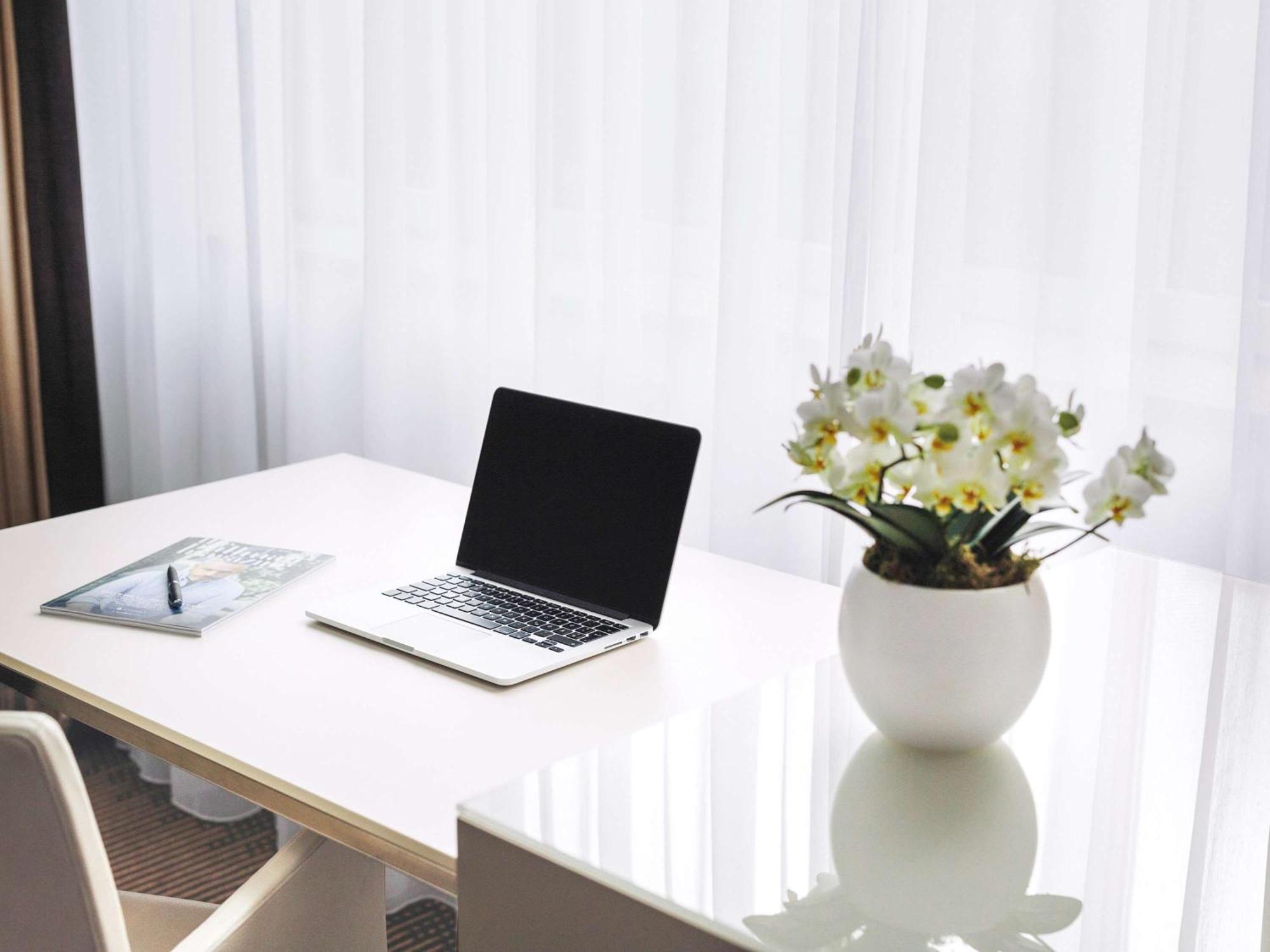Pullman Berlin Schweizerhof Hotel Bagian luar foto A desk with a laptop and a vase of flowers